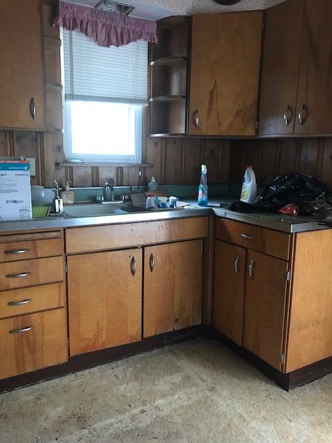 A kitchen with wooden cabinets and a stainless steel sink