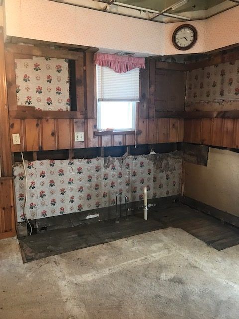An empty kitchen with a clock on the wall