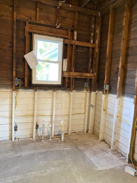 An empty room with wooden walls and a window.