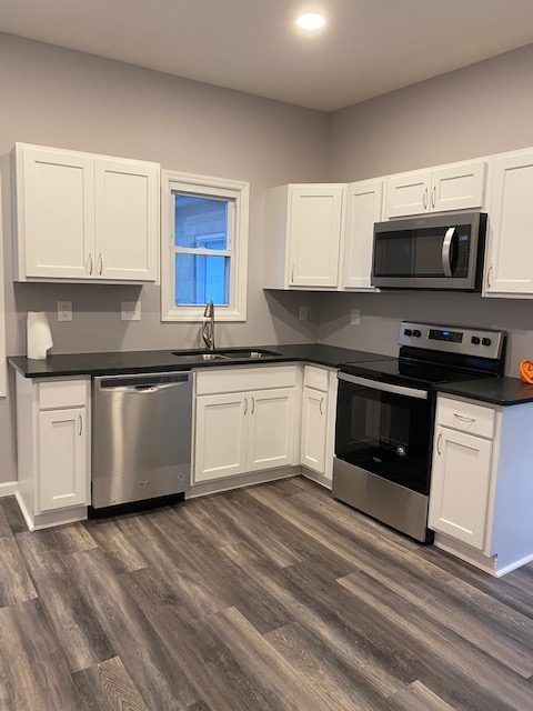 A kitchen with stainless steel appliances and white cabinets.