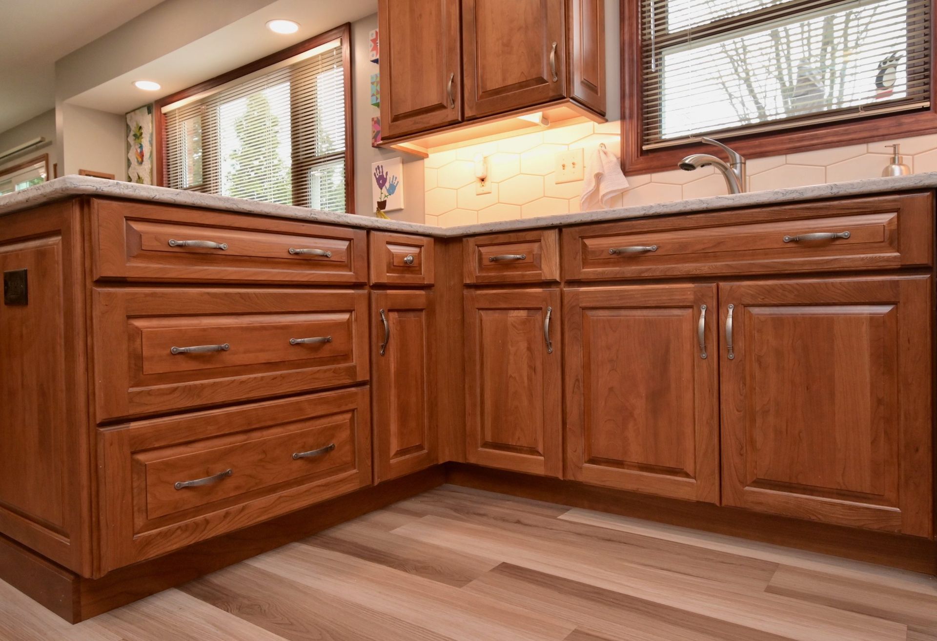 A kitchen with wooden cabinets and drawers and a sink.
