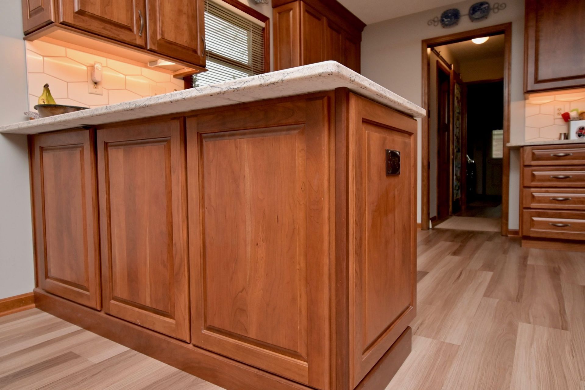 A kitchen with wooden cabinets and a large island in the middle.
