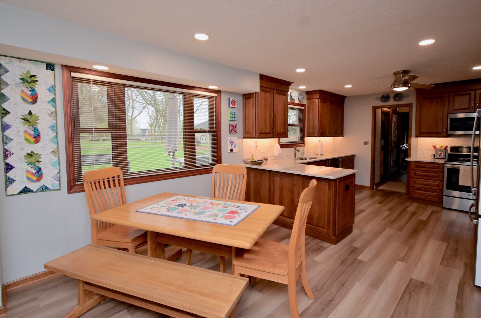 A kitchen with a table and chairs and a bench.