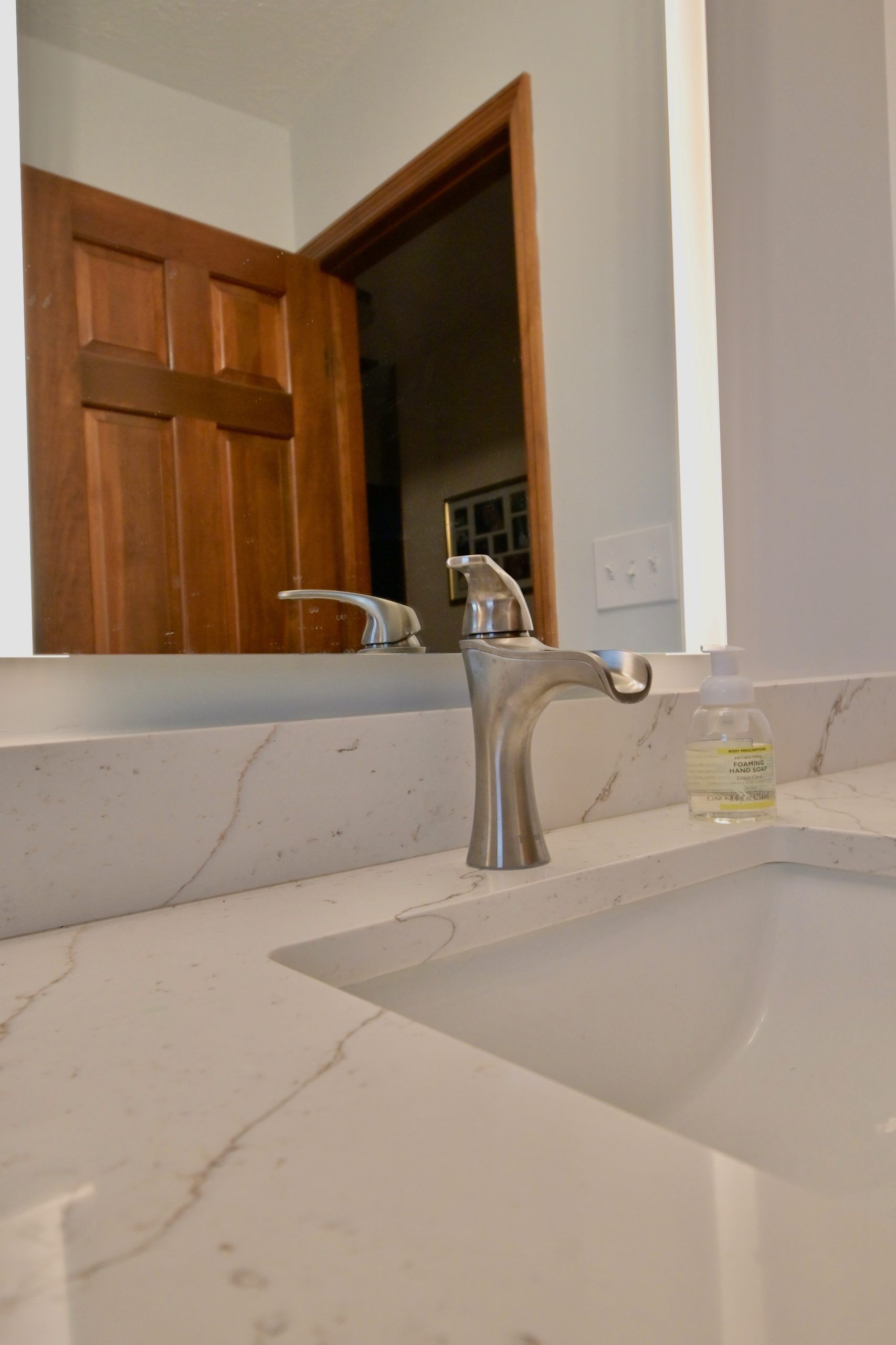A bathroom sink with a faucet and a mirror.