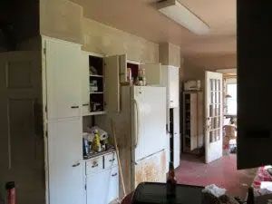 A kitchen with white cabinets and a refrigerator.