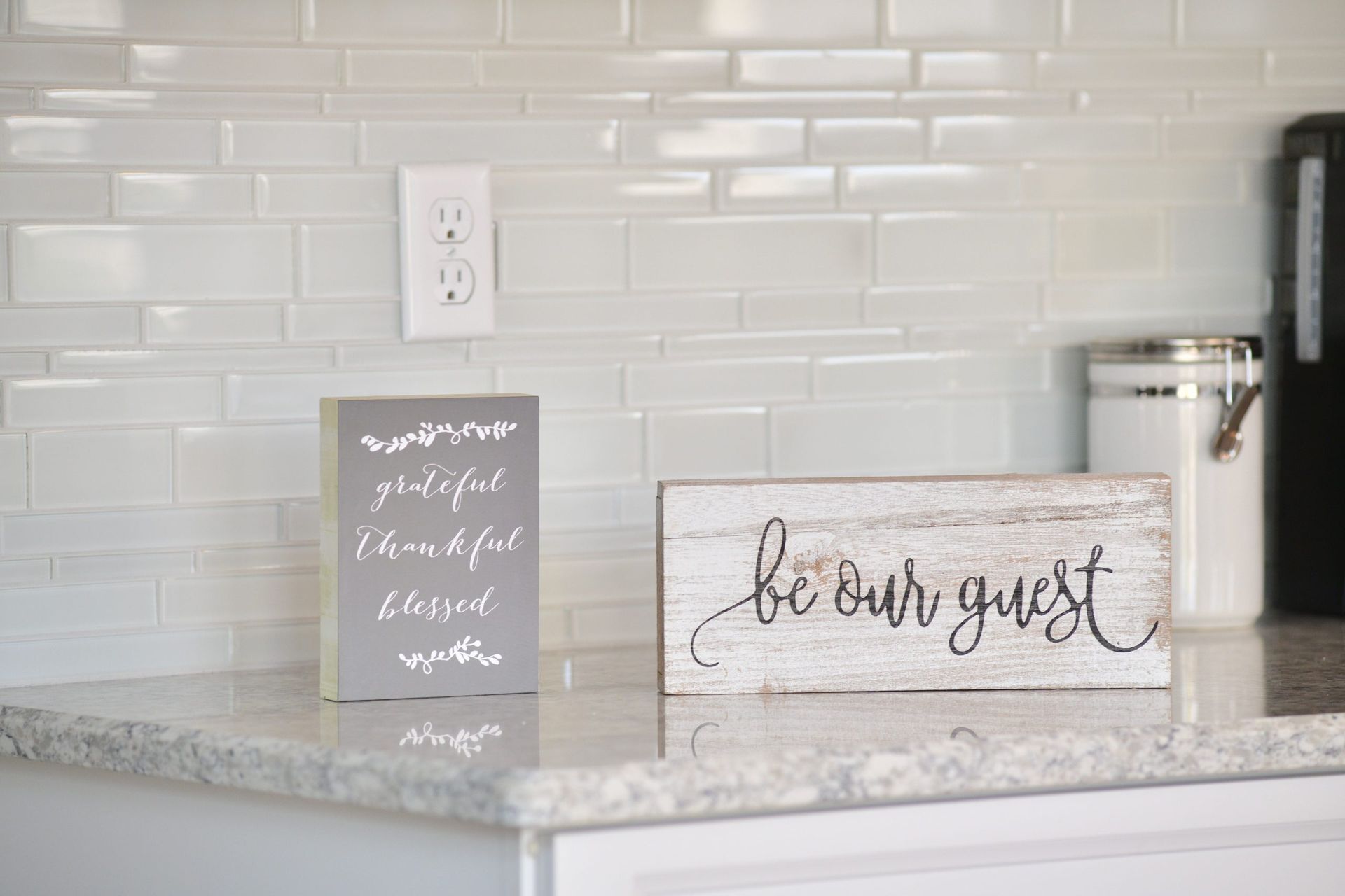A kitchen counter with a sign that says `` be our guest ''.