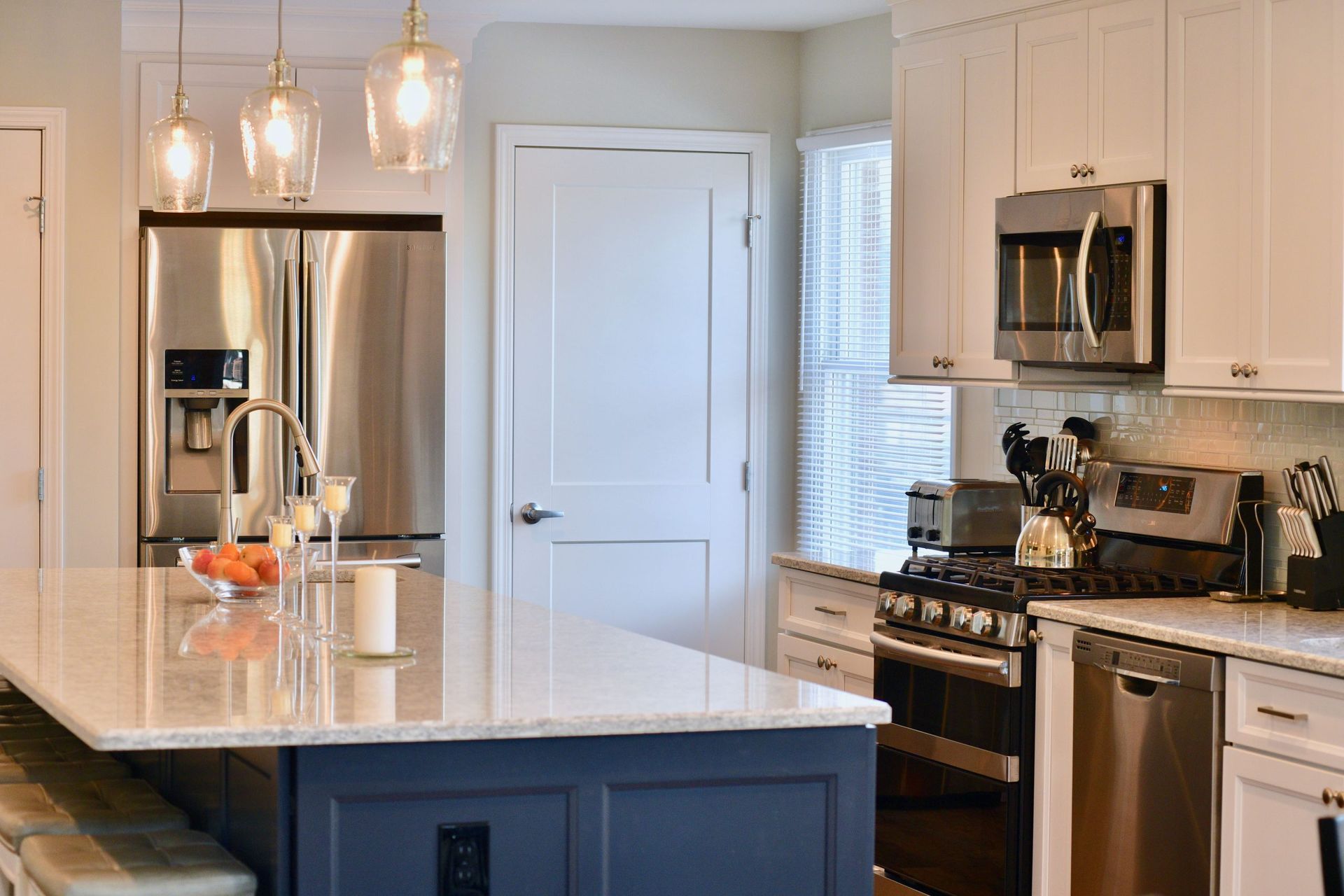 A kitchen with stainless steel appliances and white cabinets.