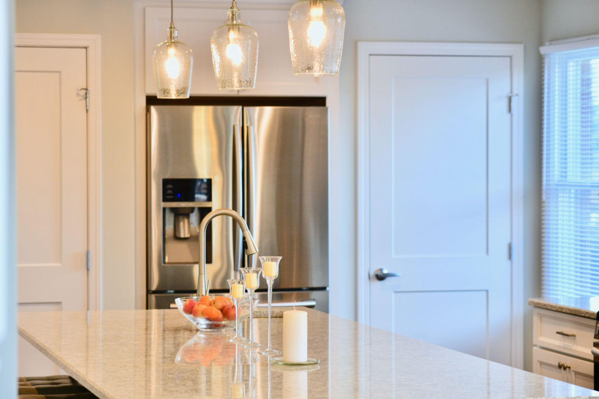 A kitchen with a stainless steel refrigerator and a sink.