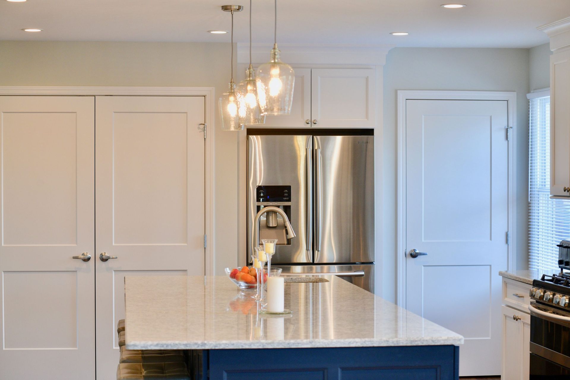 A kitchen with stainless steel appliances and a blue island.