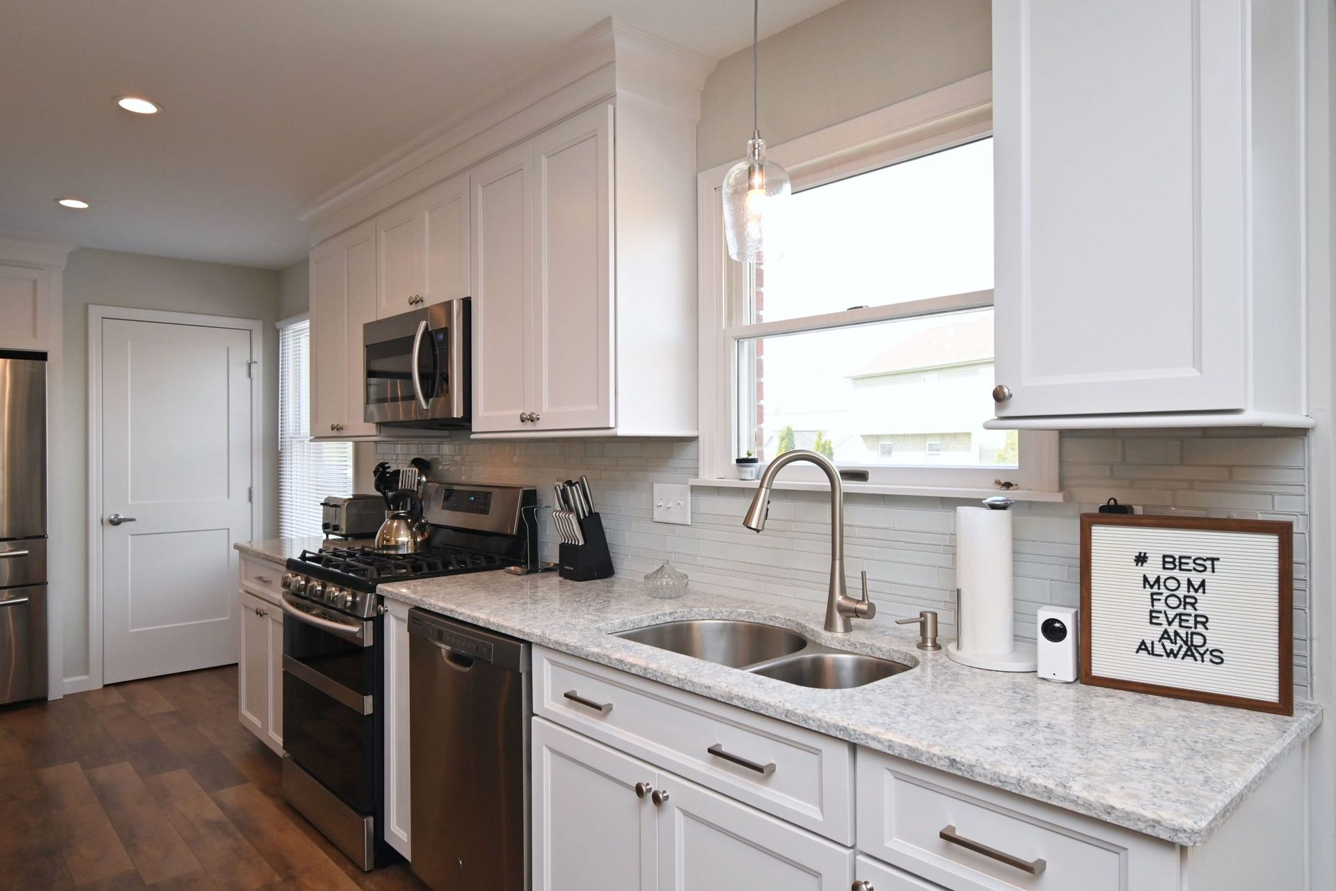 A kitchen with white cabinets and stainless steel appliances