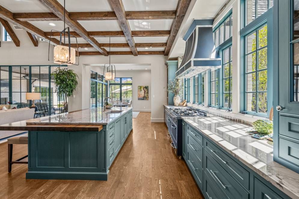 A large kitchen with blue cabinets and a large island in the middle.