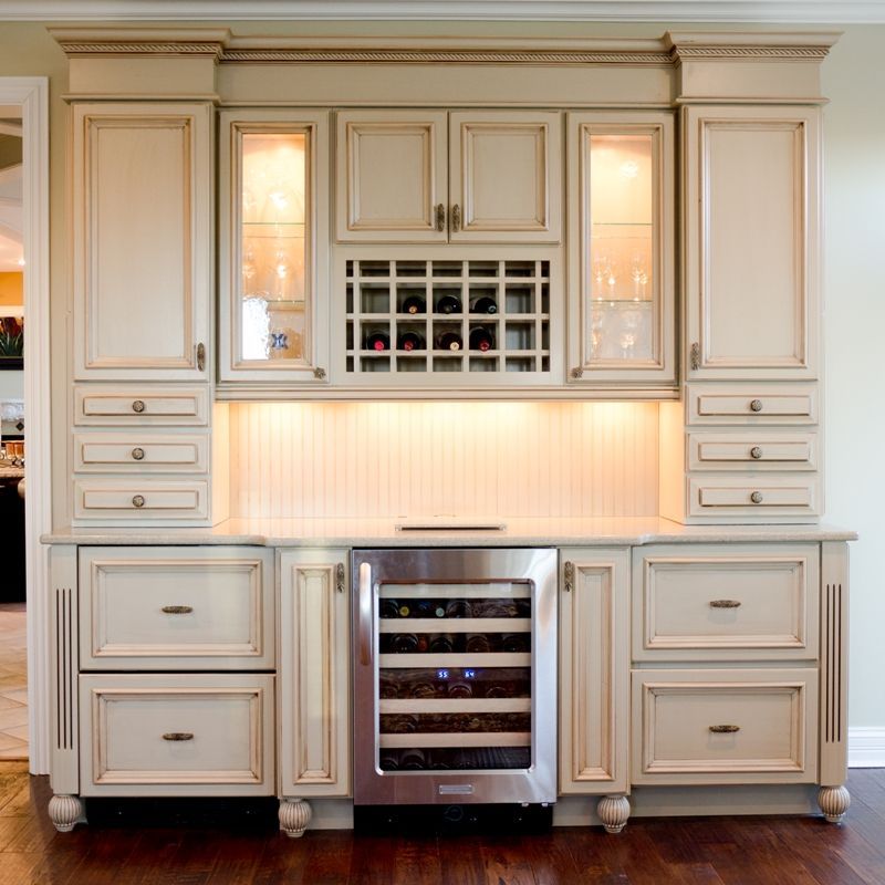 A kitchen with white cabinets and a wine cooler