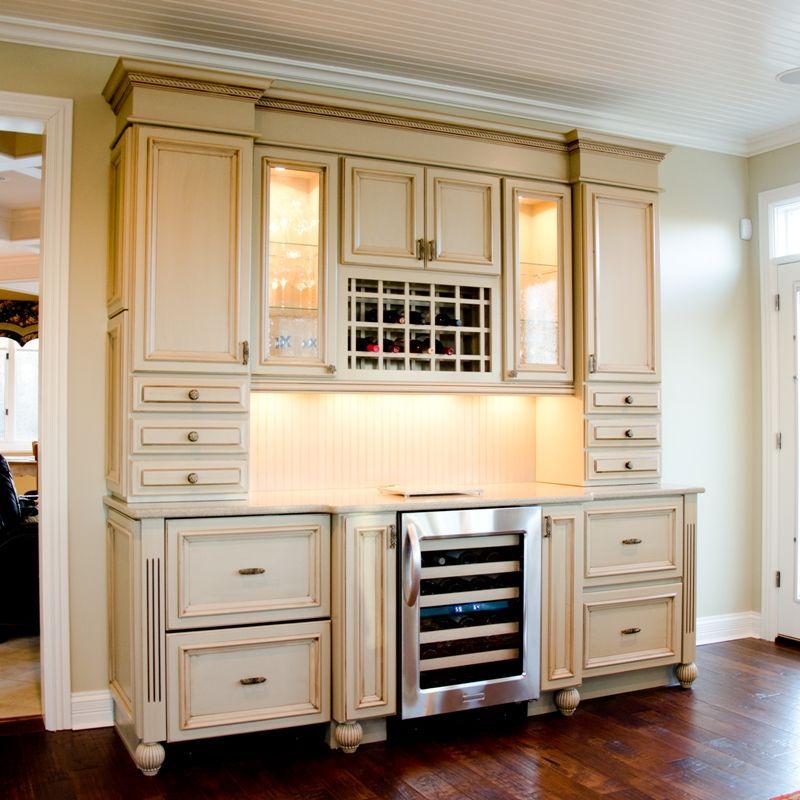 A kitchen with white cabinets and a wine cooler