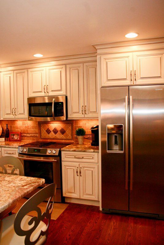 A kitchen with stainless steel appliances and white cabinets