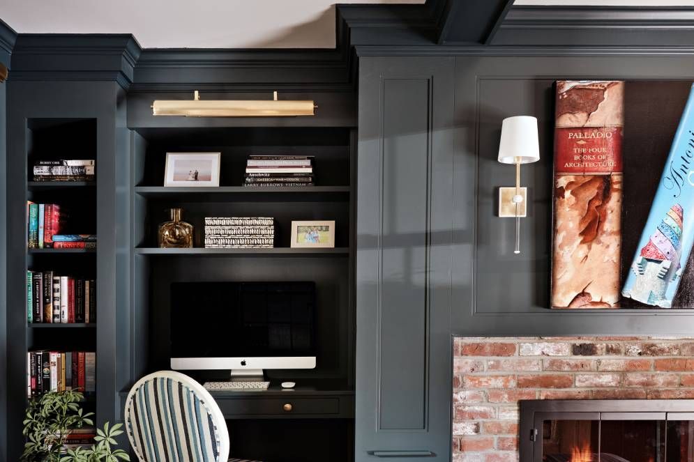 A living room with a fireplace and a desk with a computer on it