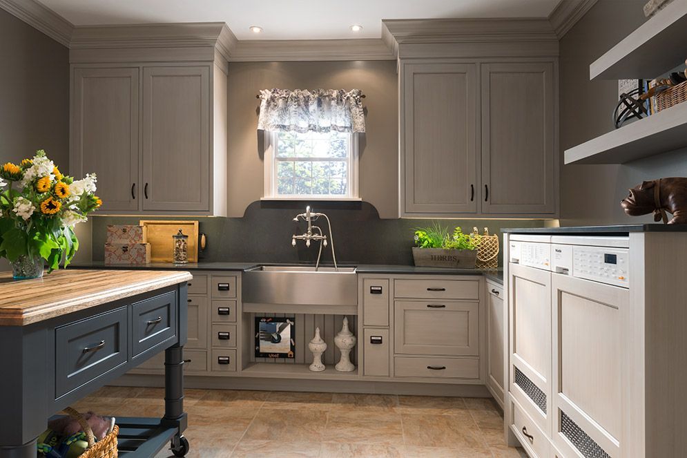 A kitchen with a sink , cabinets , a table and a window.