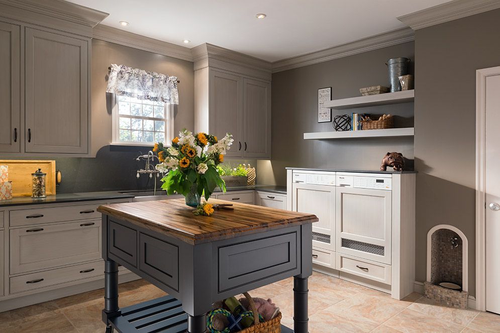 A kitchen with a large island and a vase of flowers on it.