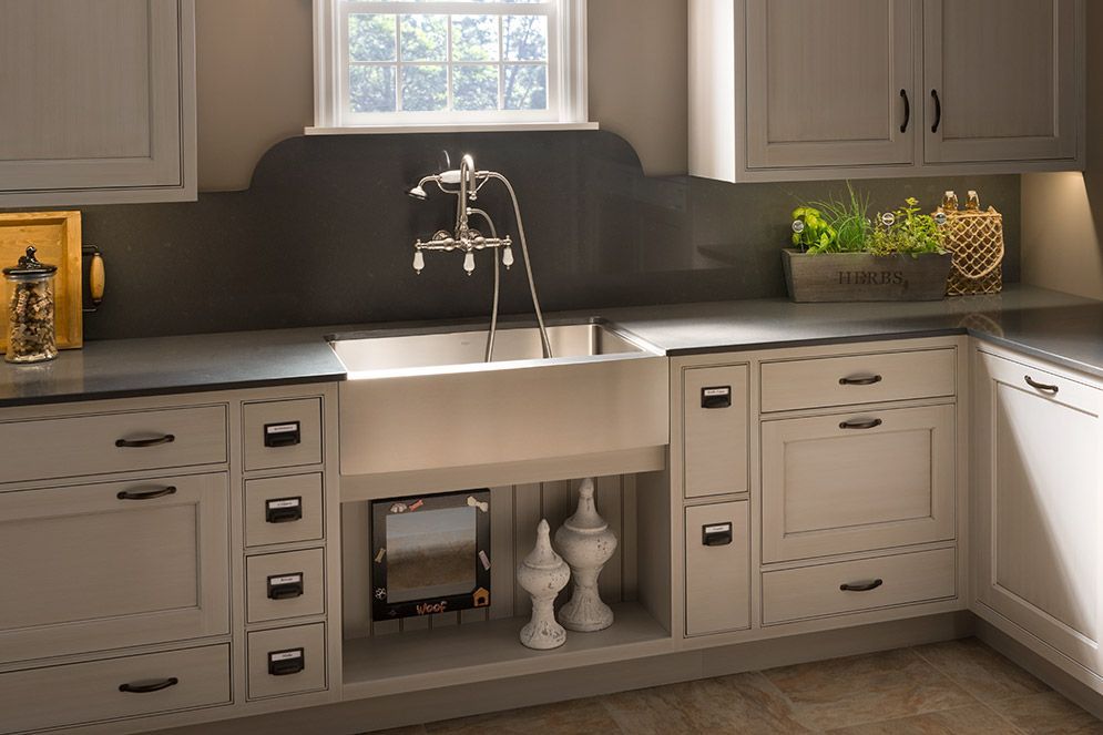 A kitchen with white cabinets and a stainless steel sink