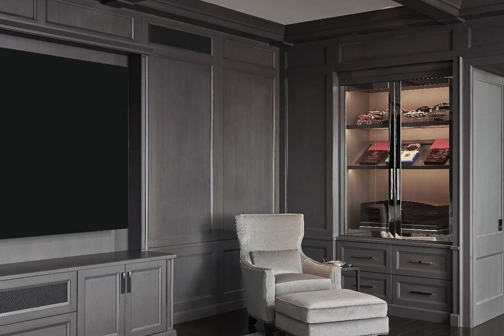 A living room with a chair and ottoman and a flat screen tv