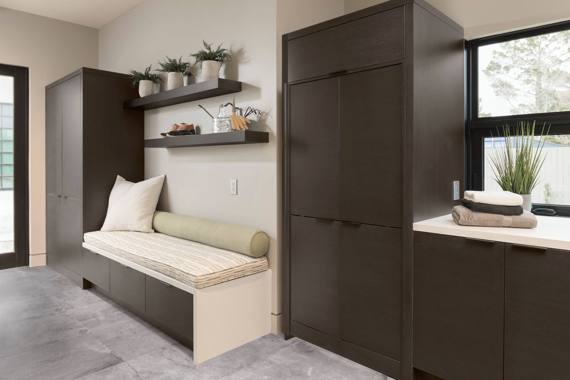 A laundry room with a bench and a window.