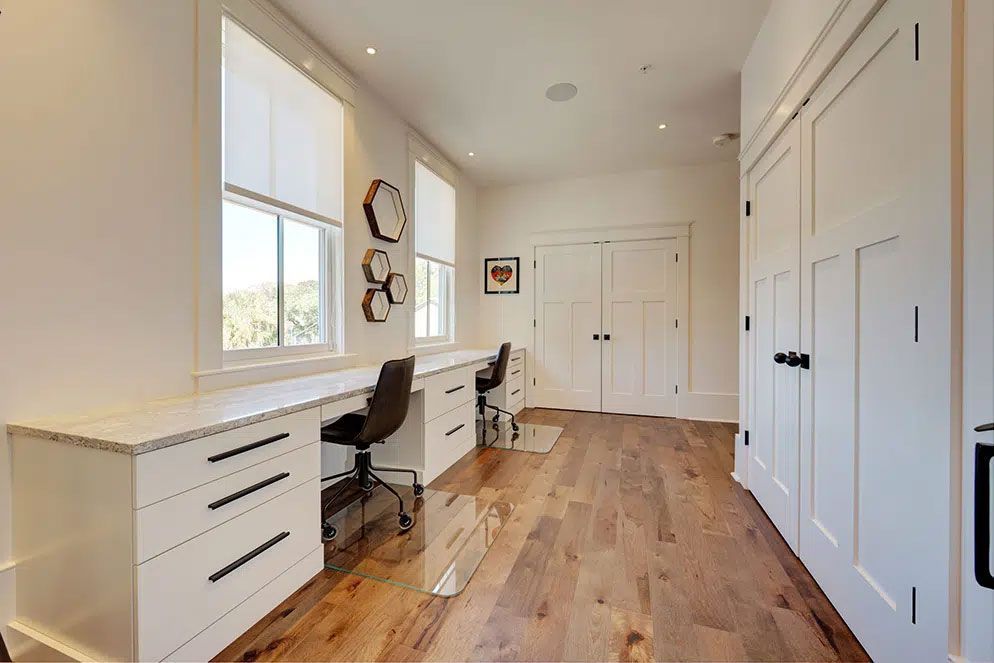 A room with two desks and a chair in it.