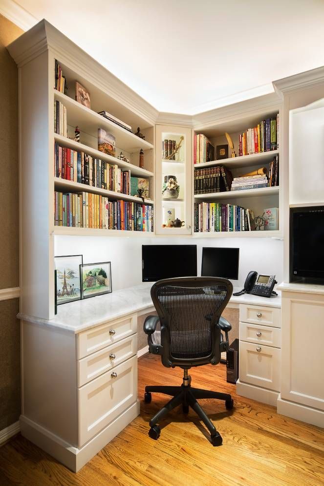 A home office with a desk , chair , computer and bookshelves.
