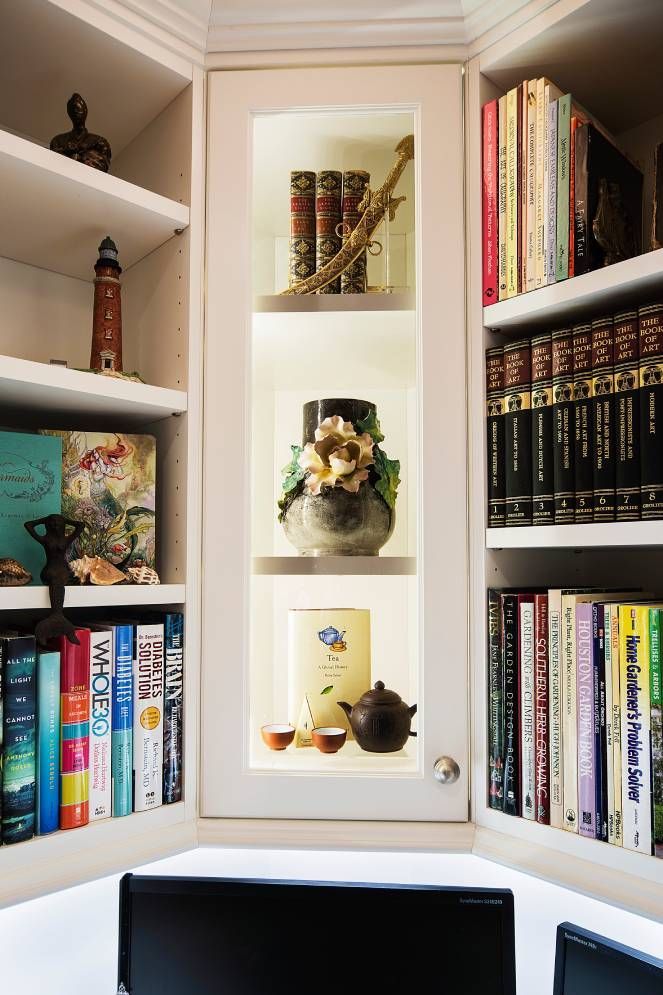 A bookshelf filled with books and a vase with flowers on it.