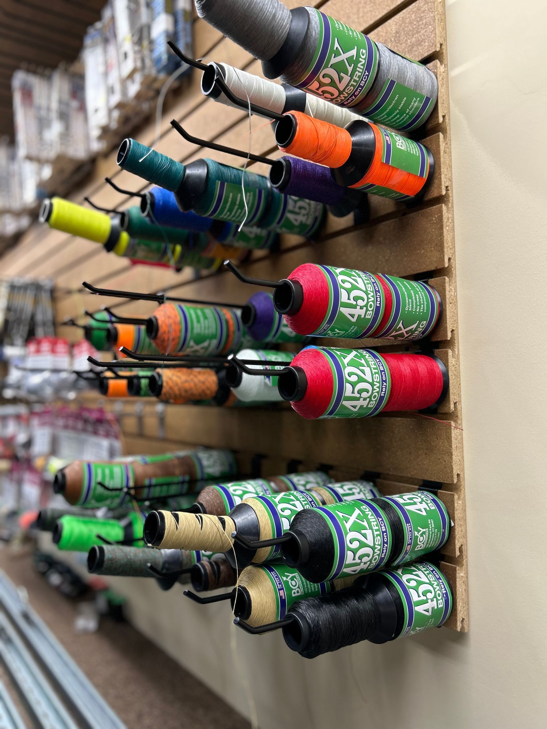 A bunch of bottles hanging on a wall one of which has the word fox on it