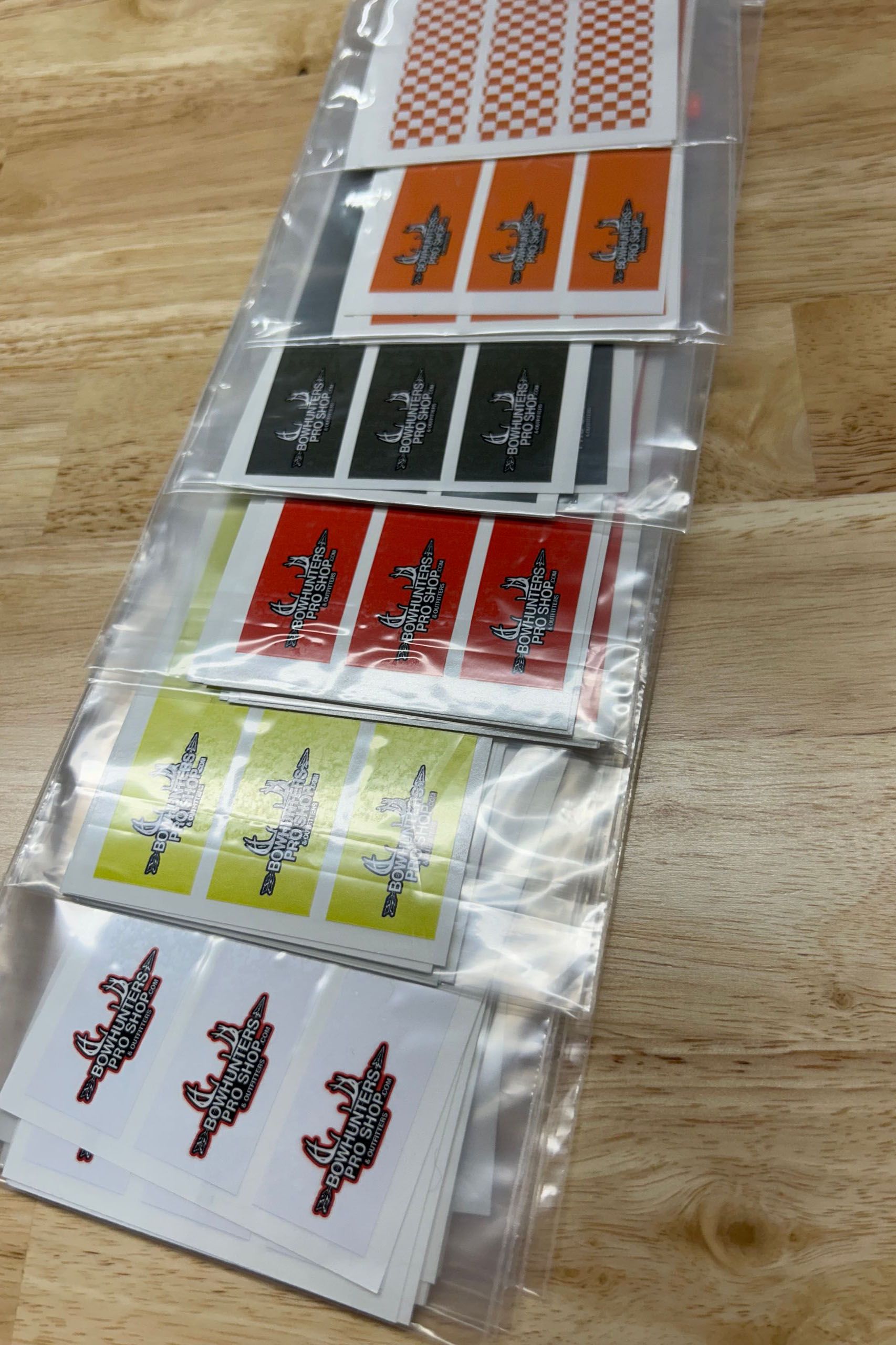 a bunch of stickers are stacked on top of each other on a wooden table