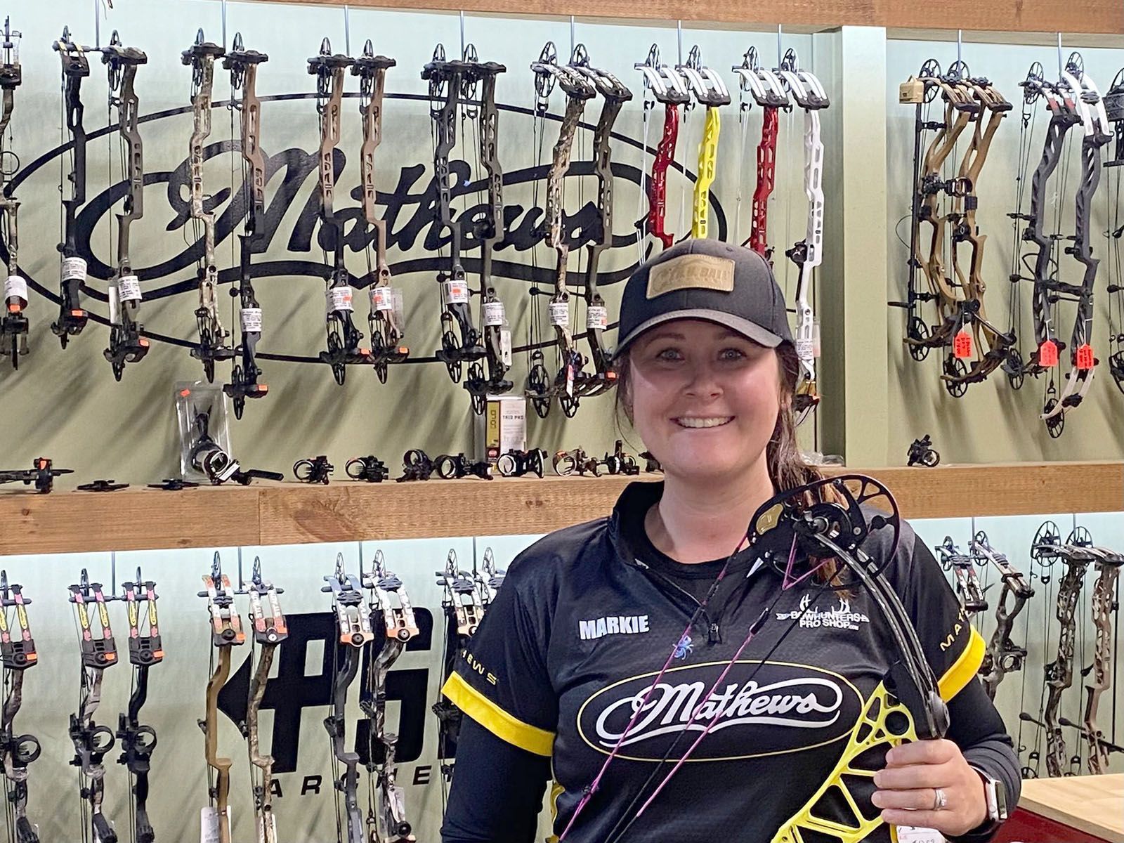 A woman in black archery shirt holding a bow