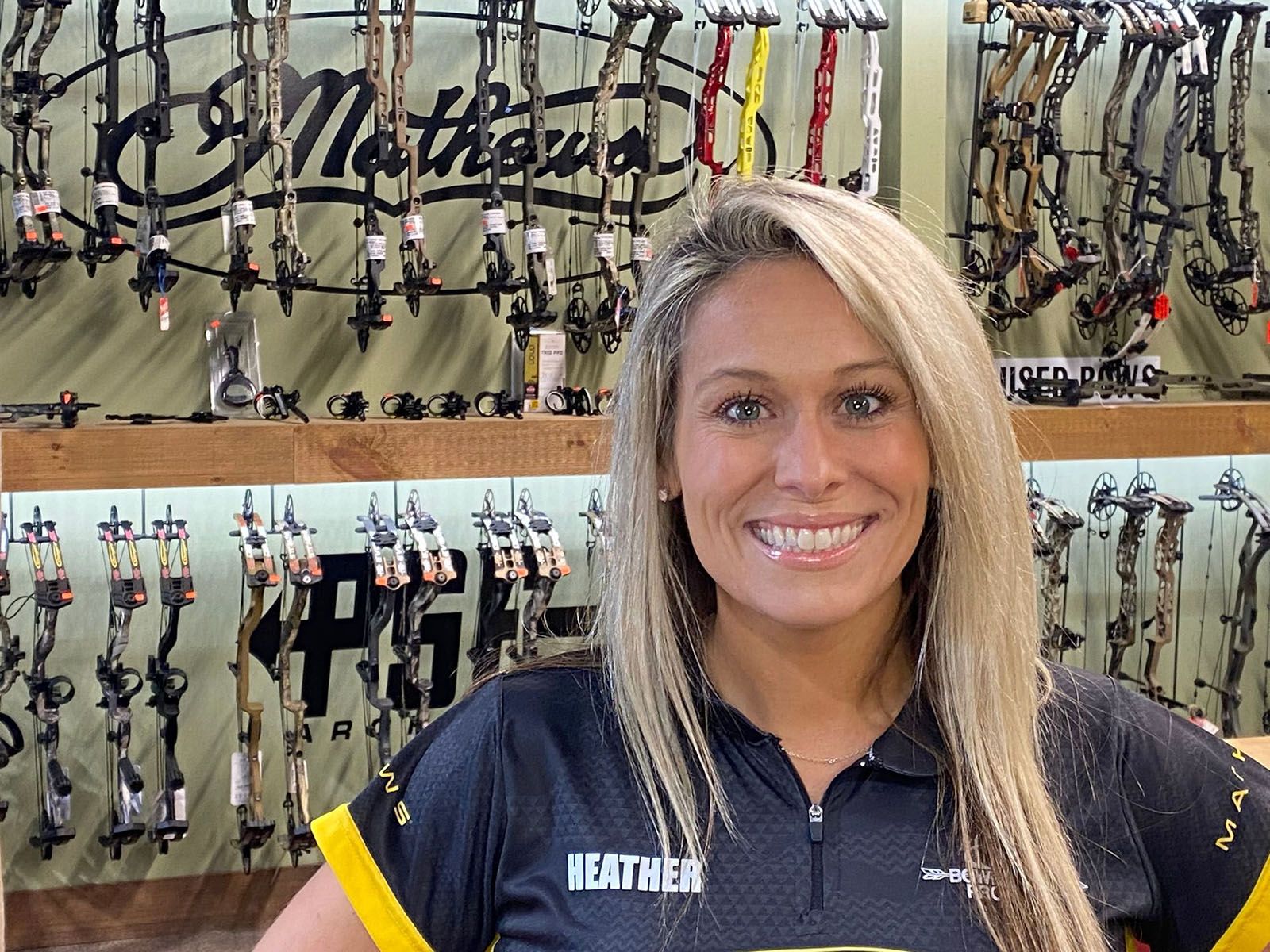 A happy woman wearing a black archery shirt