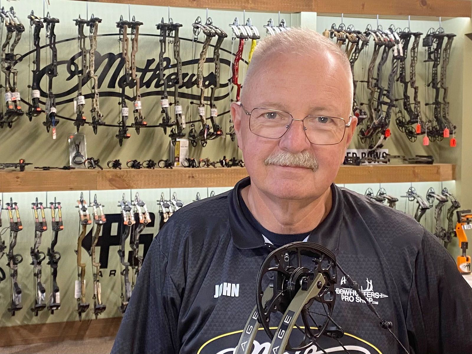 A man in a black shirt holding a bow