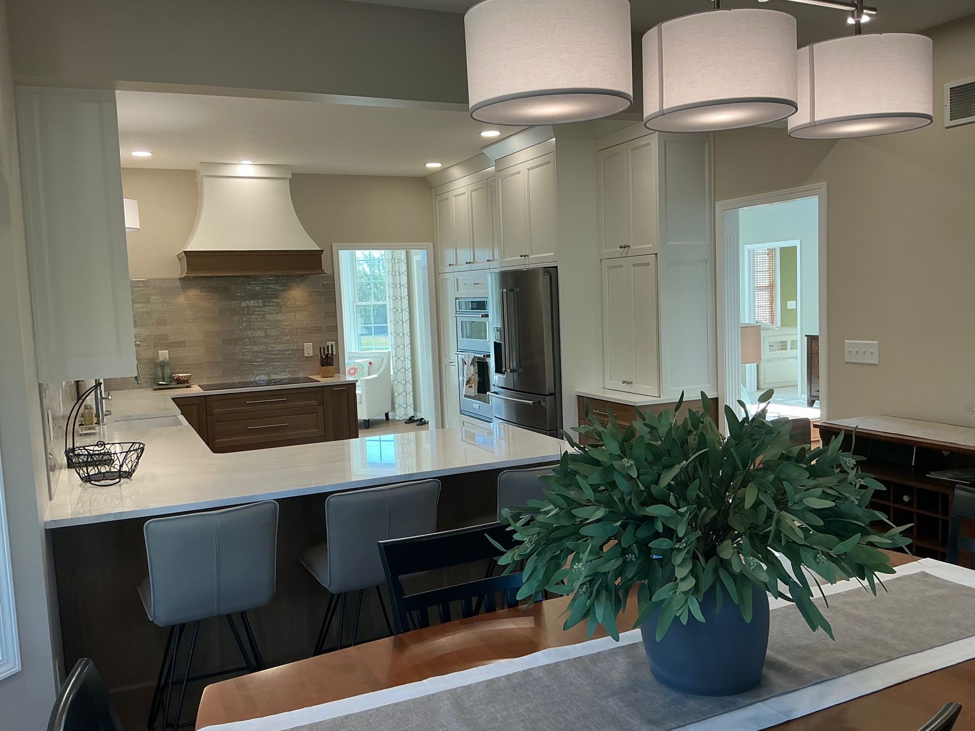 Modern kitchen with island, bar stools, and open view to dining area