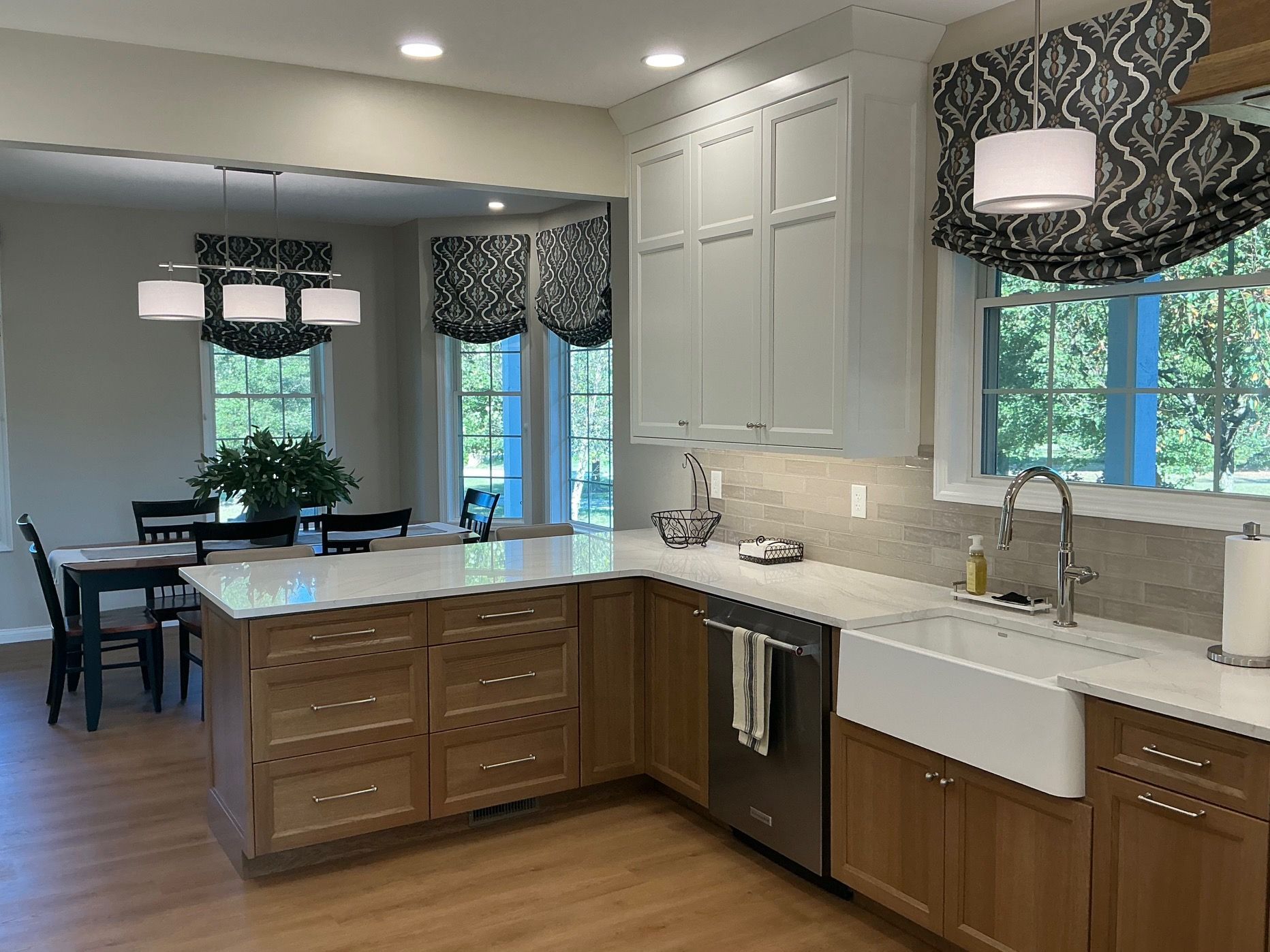 Kitchen with white cabinets, wood island, and dining area in the background