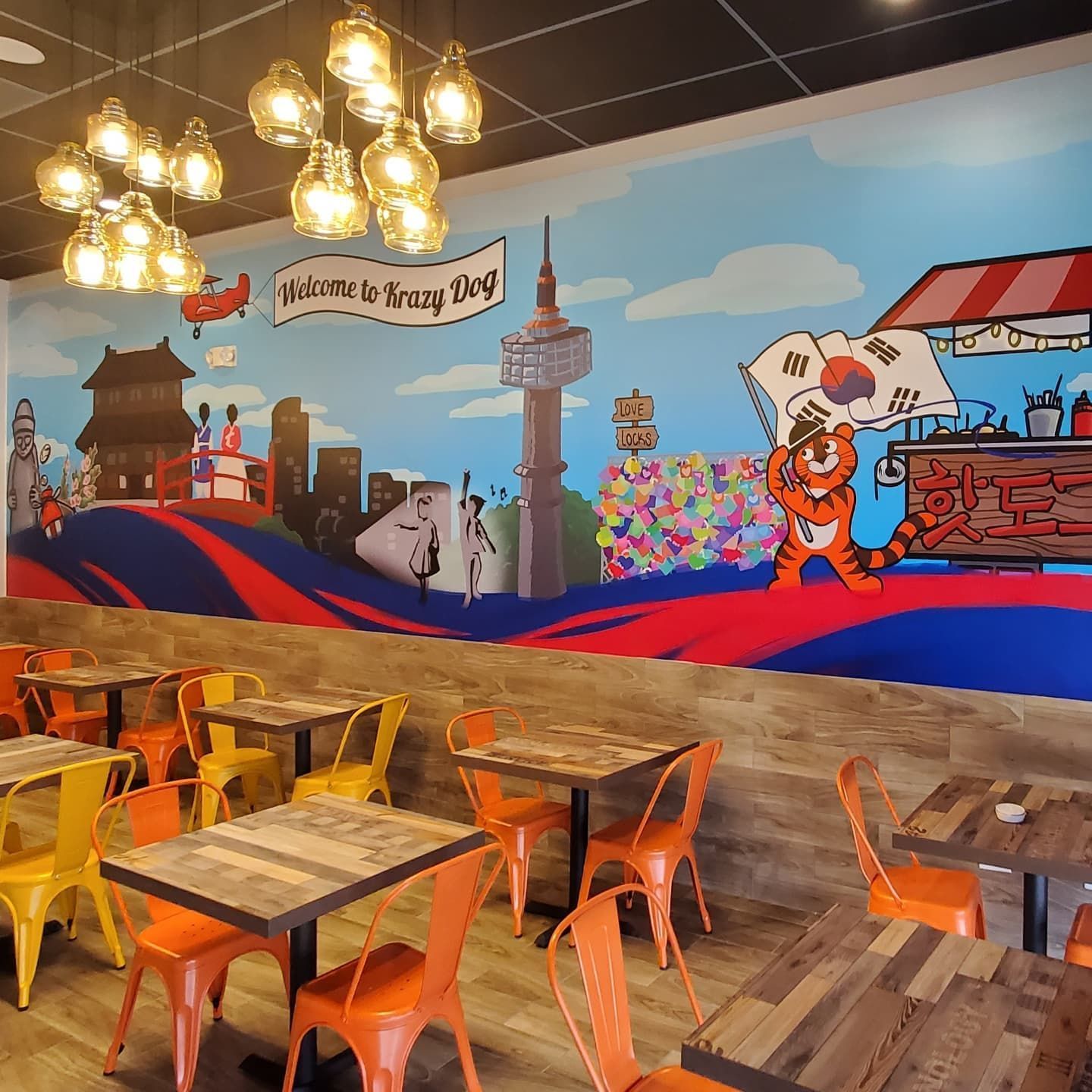 A restaurant with tables and chairs and a large mural on the wall