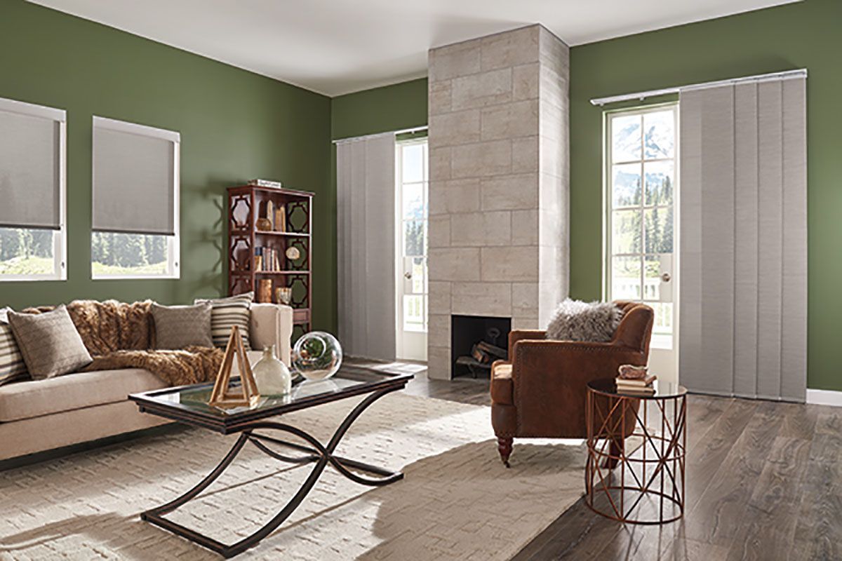 A living room with a couch , chair , coffee table and fireplace.