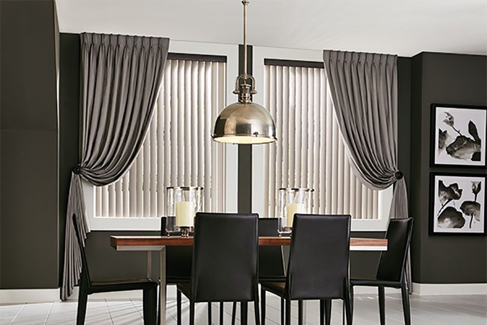 A dining room with a table and chairs and curtains
