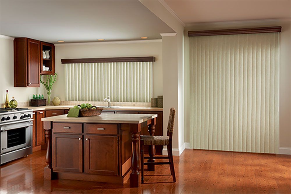 A kitchen with a large island and white vertical blinds