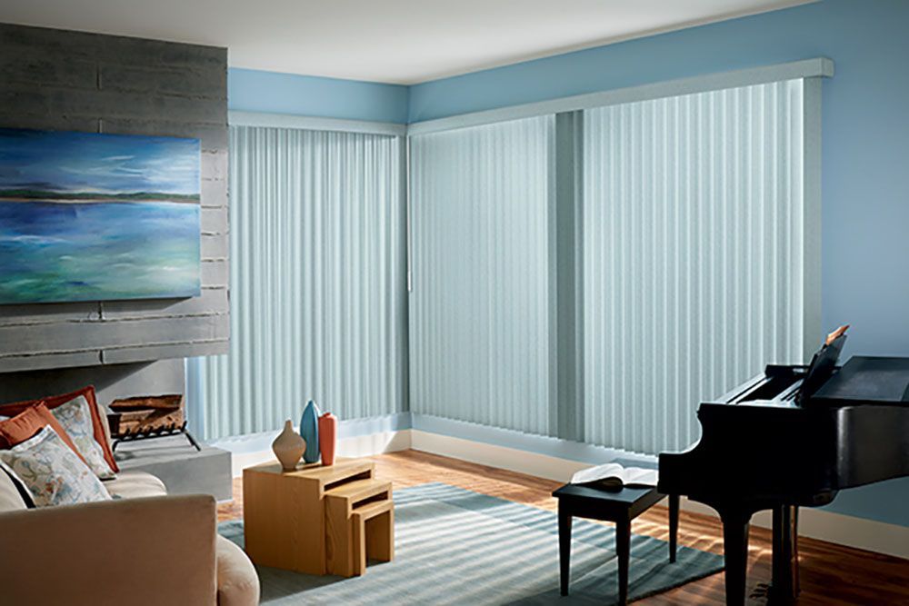 A living room with a piano , couch , table and blinds.