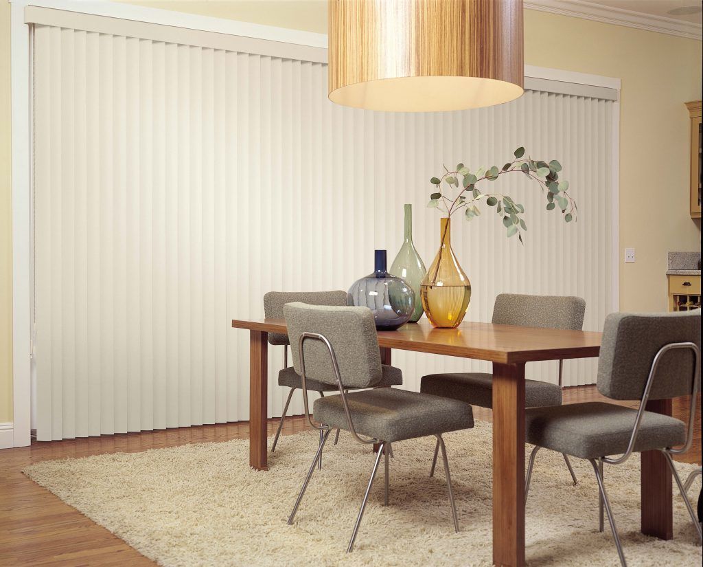 A dining room with a table and chairs and white blinds