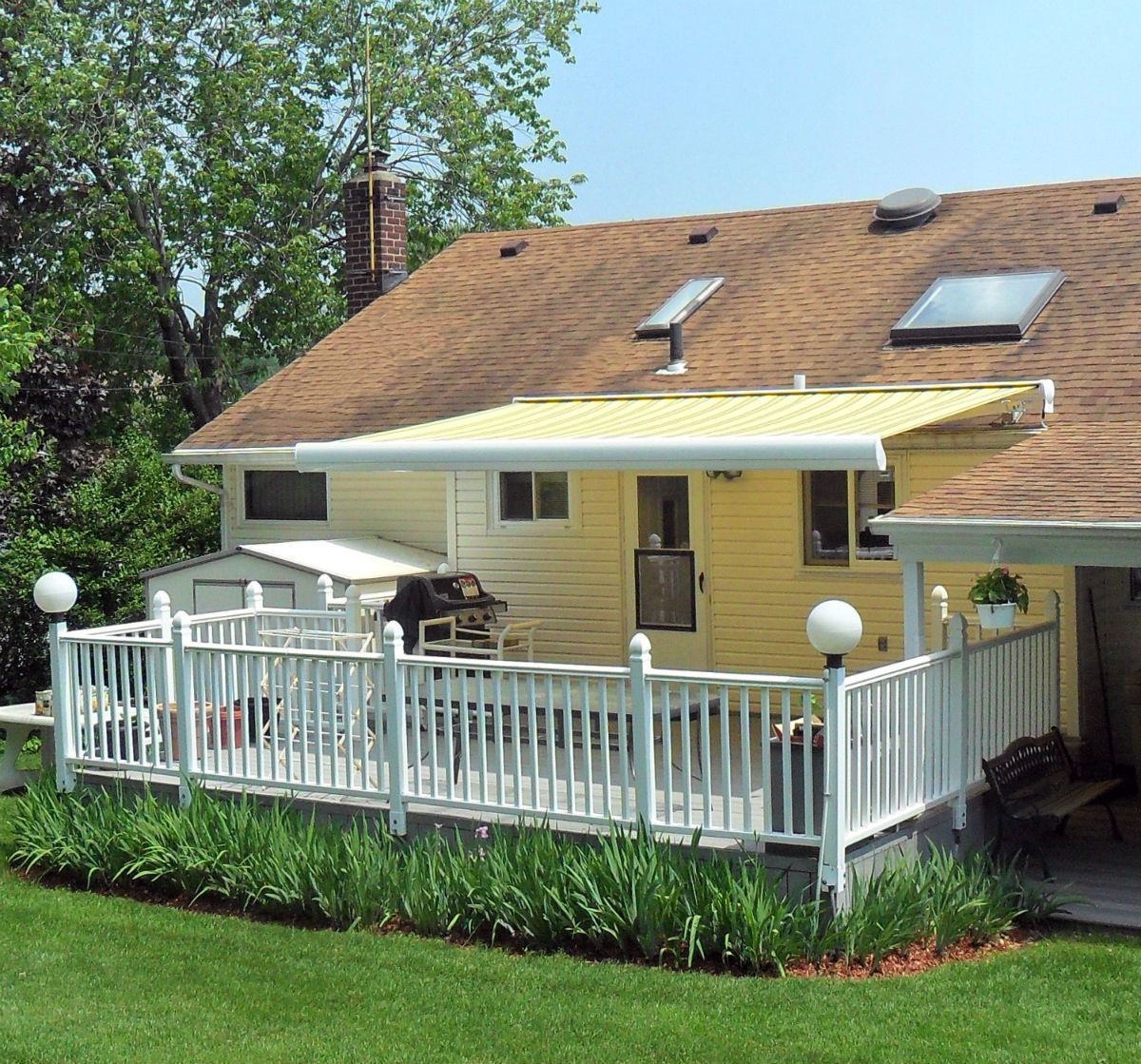 A house with a large deck and a yellow awning
