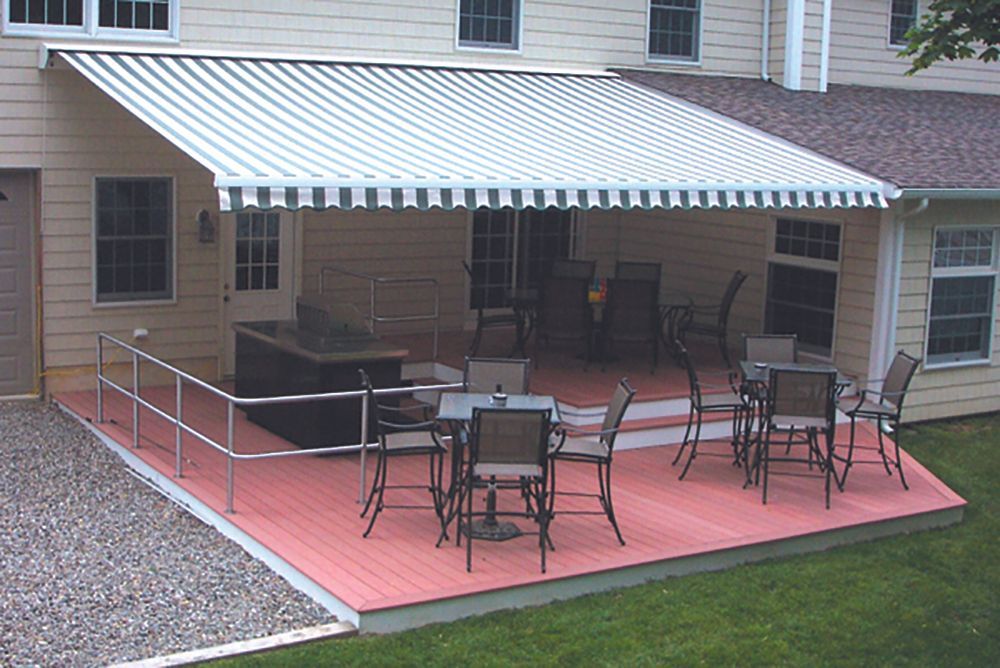 A patio with tables and chairs under an awning