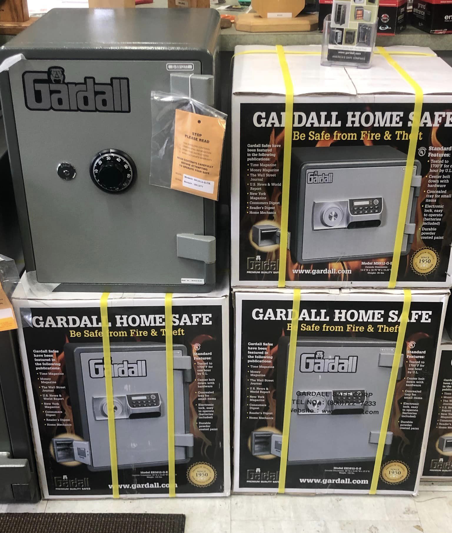 Gray Gardall safe and three boxes of Gardall Home Safes, stacked in a store.