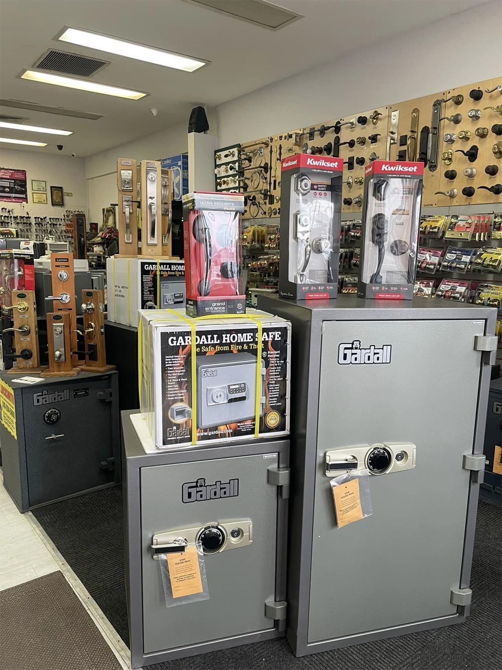 Interior of a locksmith shop showcasing safes and door hardware displays.