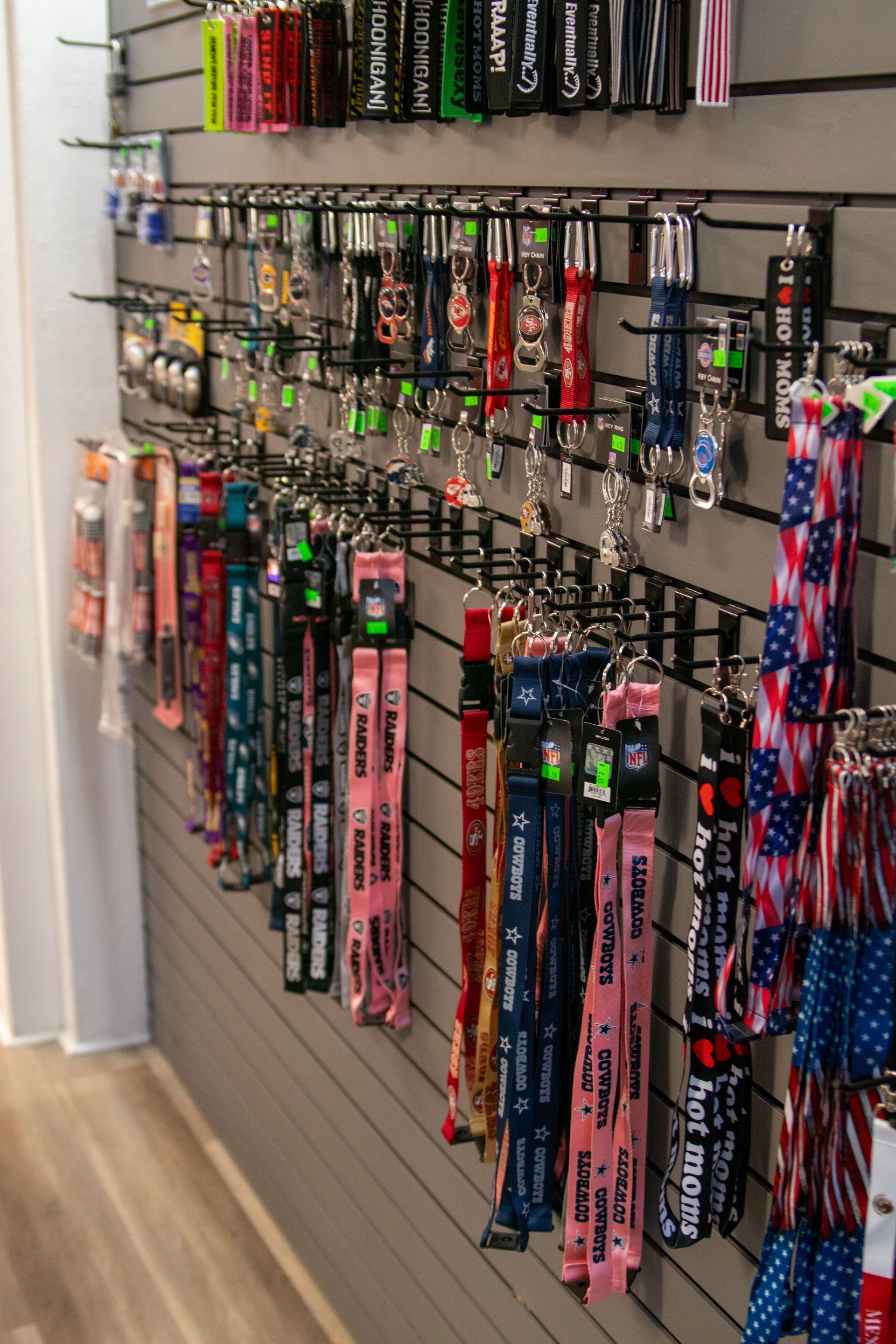A bunch of lanyards are hanging on a wall in a store.