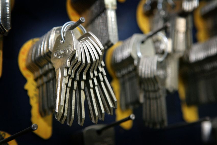 A bunch of keys hanging on a hook on a wall.