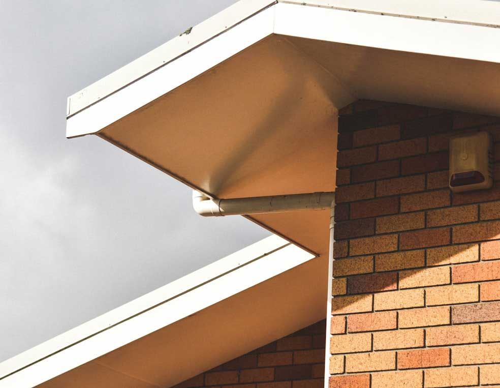 A brick building with a white roof and white trim