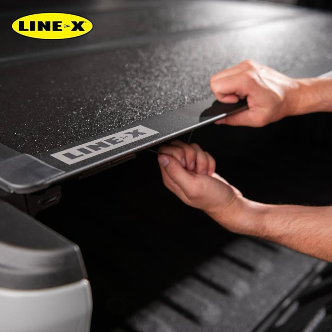 A person is opening a line-x truck bed cover