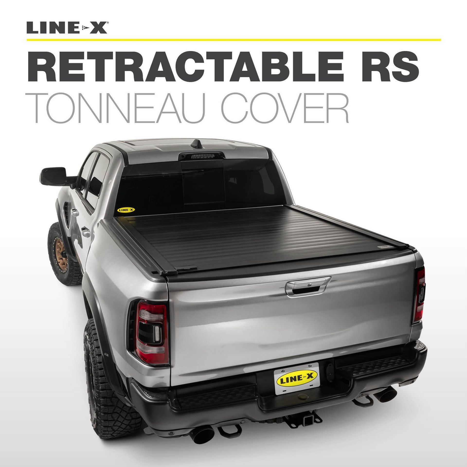 A silver truck with a black tonneau cover on it.