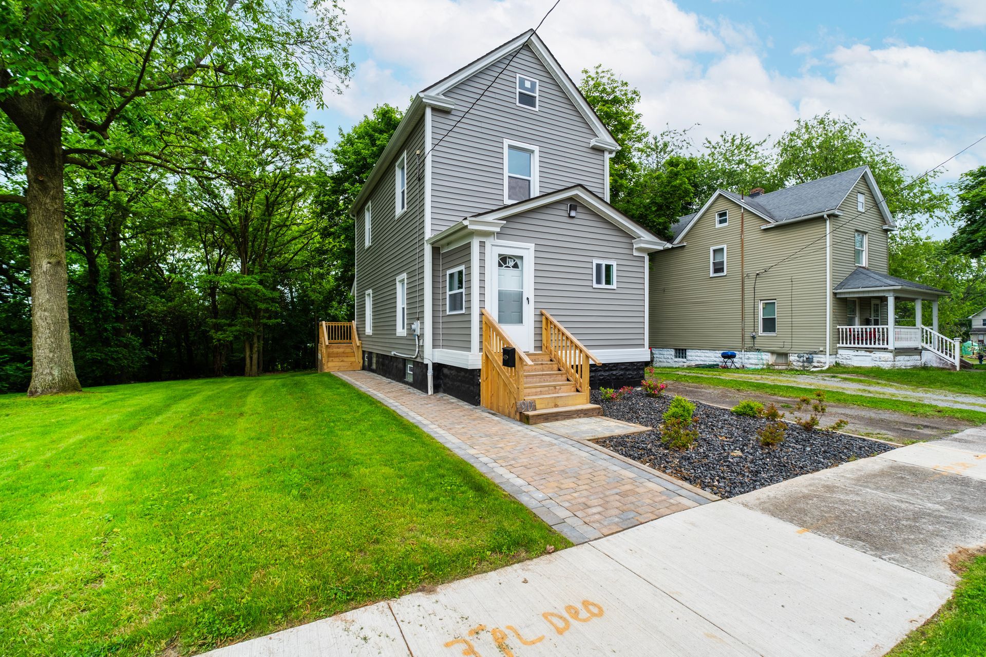 A house with a lawn and a sidewalk in front of it